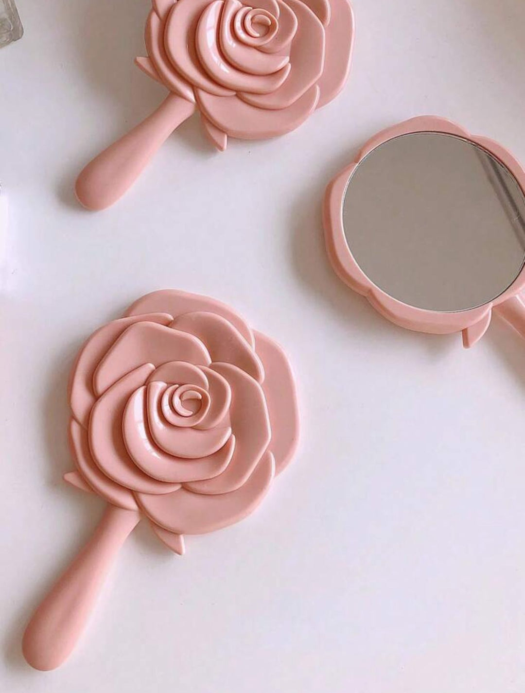Carnation-colored mirror in the shape of a rose | مرآة يد بتصميم وردة